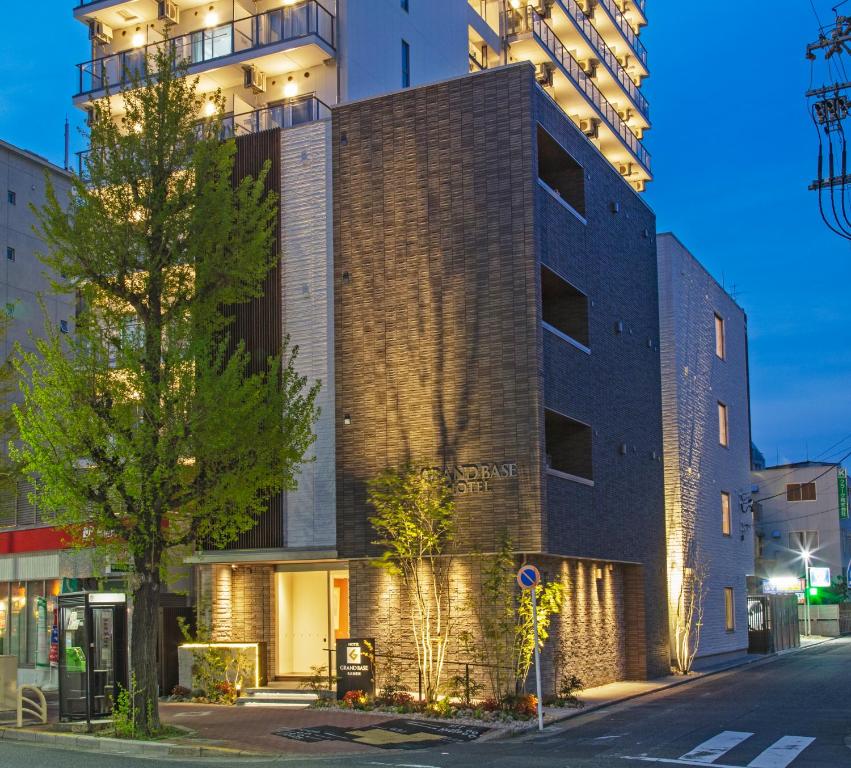 un edificio in una strada di fronte a un palazzo alto di GRAND BASE Nagoya Ekinishi a Nagoya