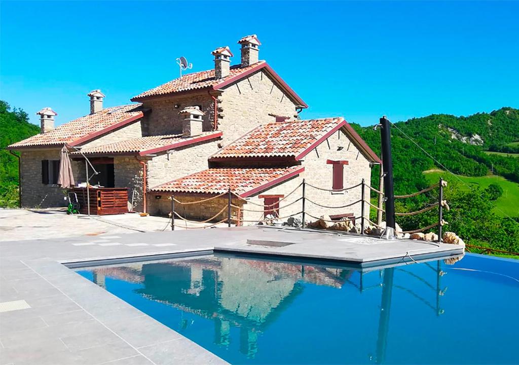 a house with a swimming pool in front of it at Agriturismo Il Cornio in Sarsina