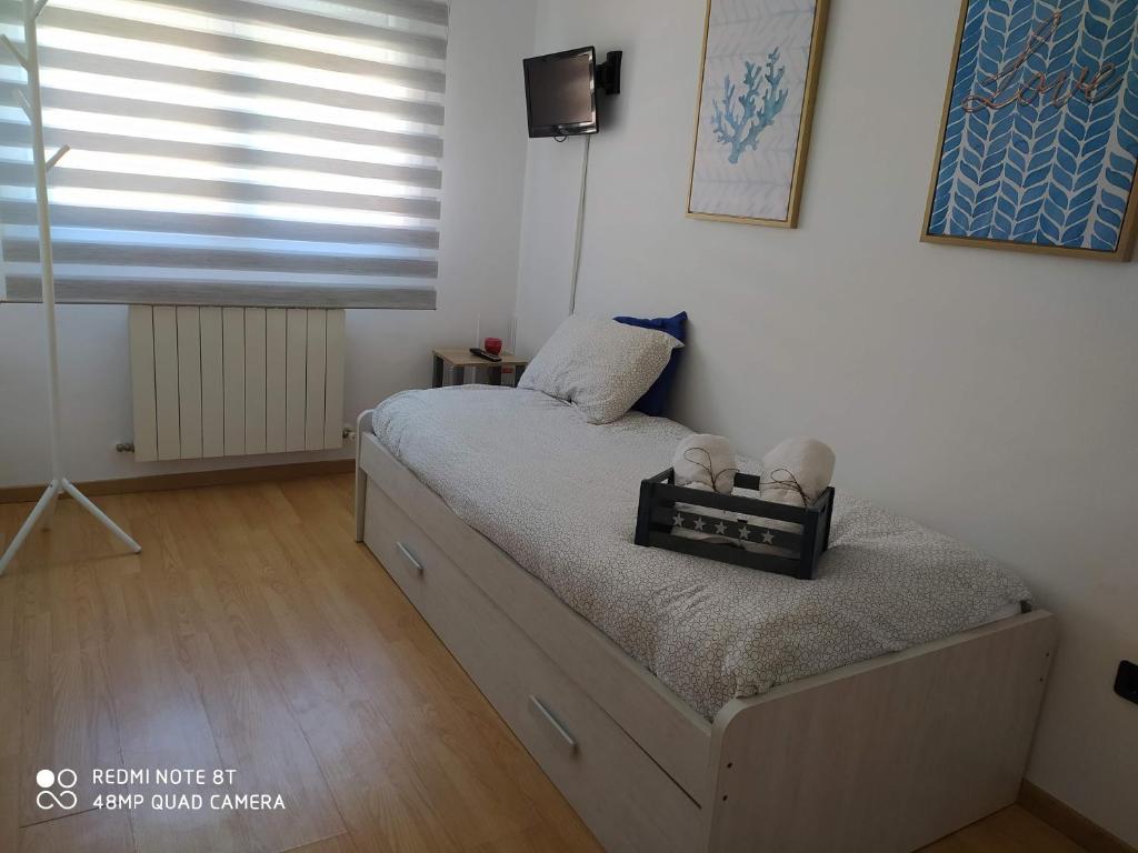 a small bedroom with a bed with a window at Vianatxiki in Viana