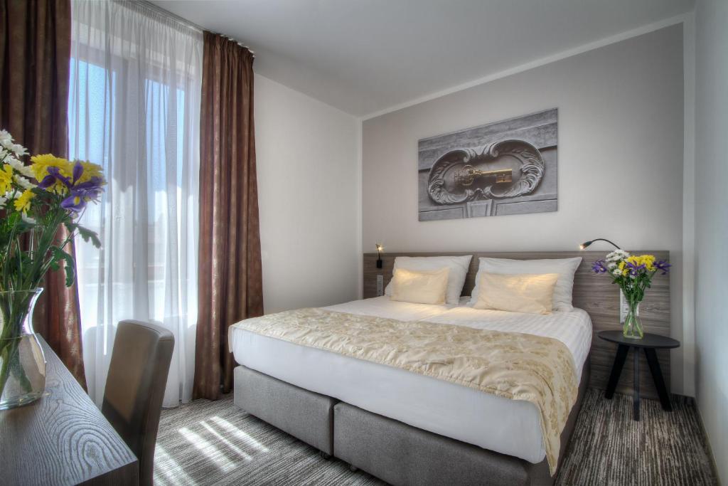 a hotel room with a bed and a window at Hotel Páv in Prague