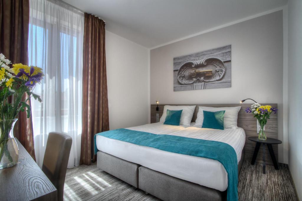a hotel room with a large bed and a window at Hotel Páv in Prague