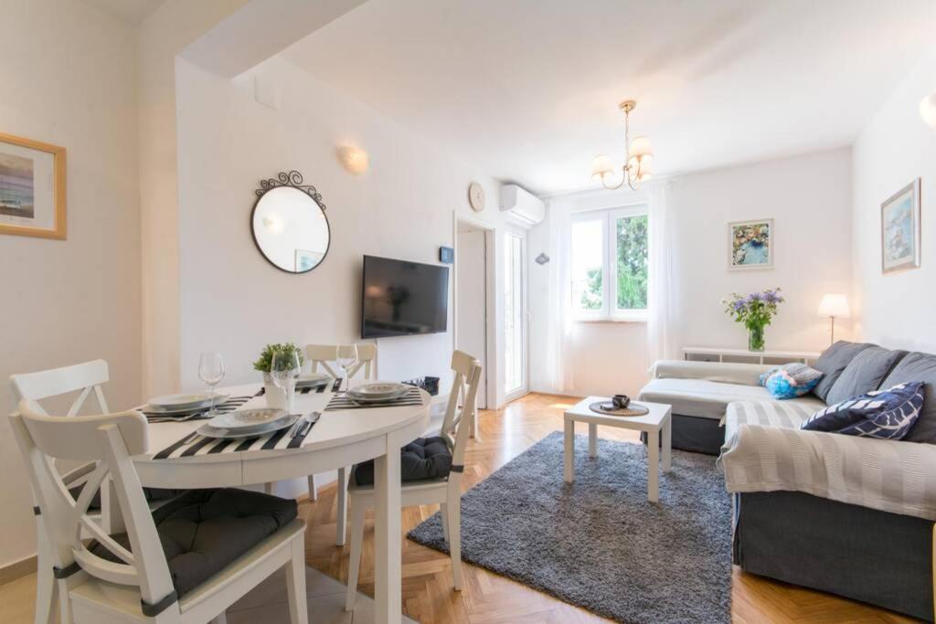 una sala de estar con una mesa y un sofá en Flora three bedroom apartment near beach, en Dubrovnik