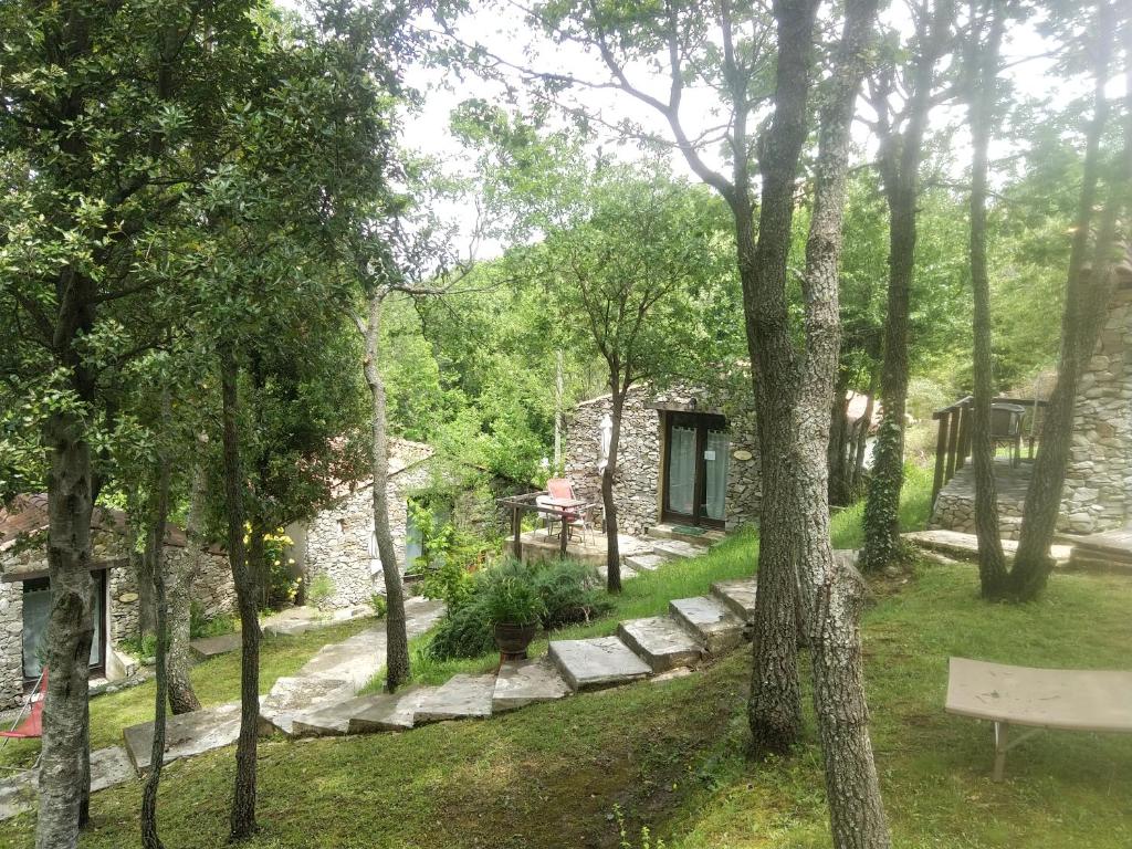 uma casa de pedra na floresta com um banco em Villa Praesidio em Riventosa