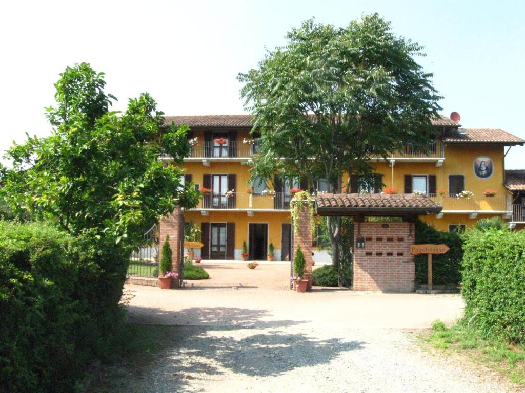 a large yellow building with a tree in front of it at Residence La Bellotta in Oleggio