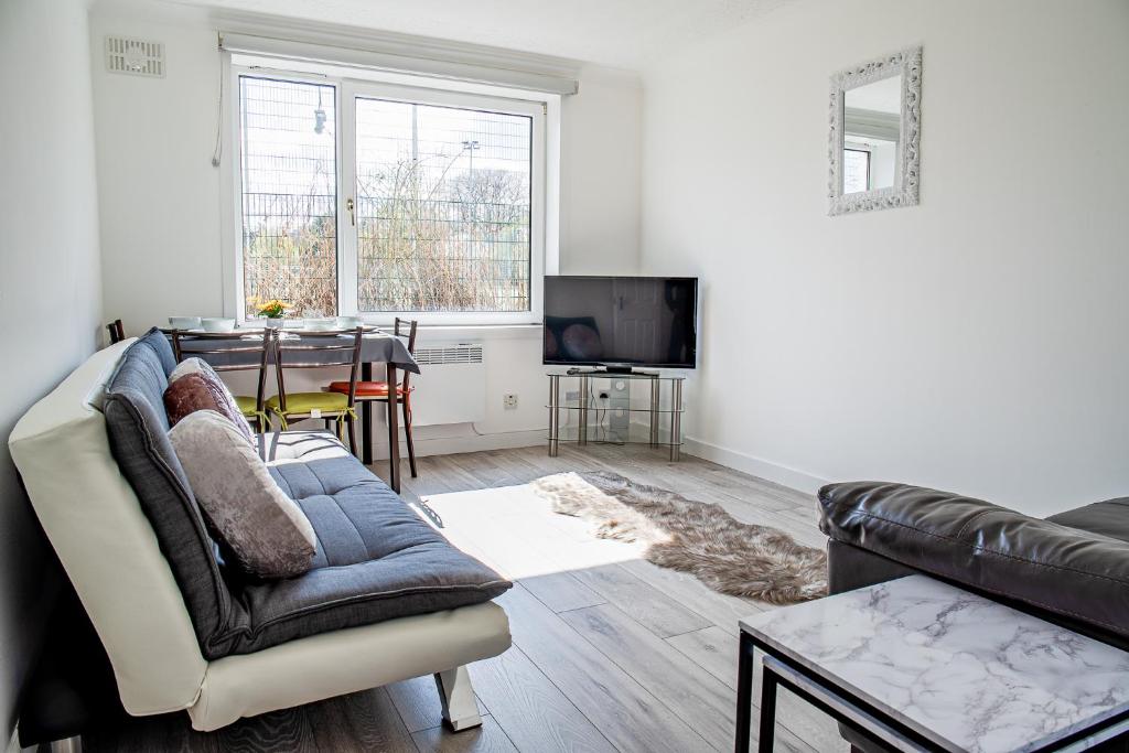 ein Wohnzimmer mit einem Sofa und einem Tisch in der Unterkunft Millburn Apartment in Inverness