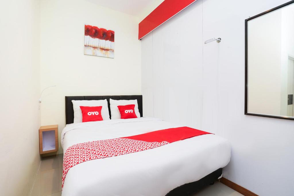 - une chambre avec un lit blanc et des oreillers rouges dans l'établissement SUPER OYO Flagship 3688 Pot Art, à Surabaya