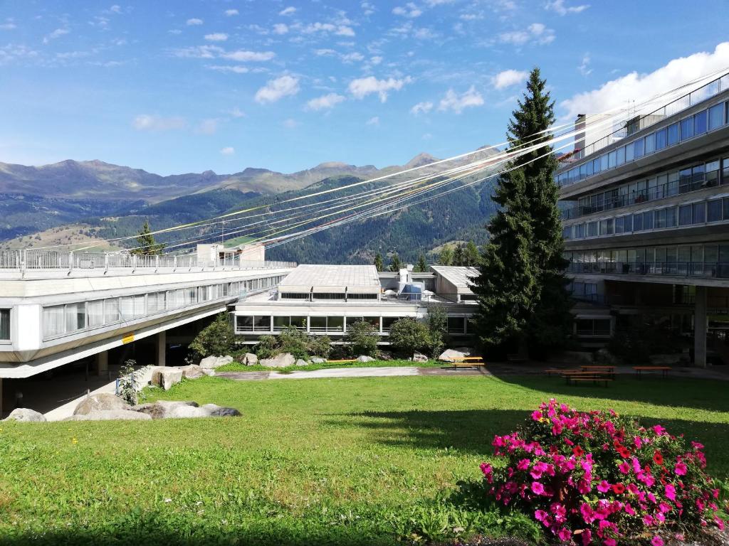 a building with a yard with flowers in front of a building at Marilleva 1400 Appartamenti Montana in Marilleva