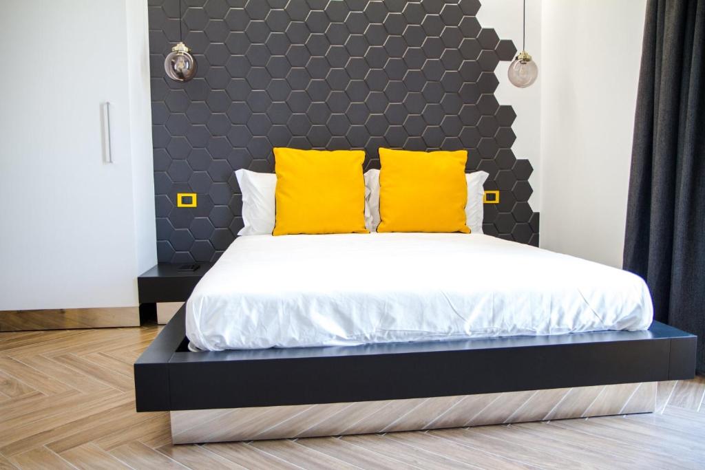 um quarto com uma cama grande e almofadas amarelas em Amarillo B.&B. GAETA em Gaeta