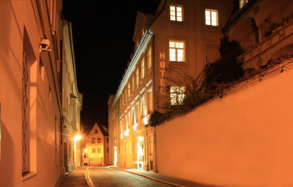 une rue urbaine vide la nuit avec des bâtiments dans l'établissement Altstadthotel Augsburg, à Augsbourg