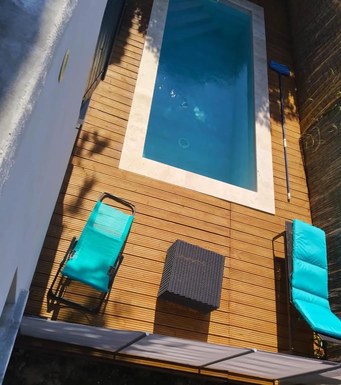 - deux chaises bleues installées à côté de la piscine dans l'établissement Les lauriers roses, à Narbonne