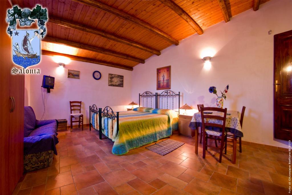 sypialnia z łóżkiem, stołem i krzesłami w obiekcie Alle Riserve Vendicari w mieście Casa Maccari