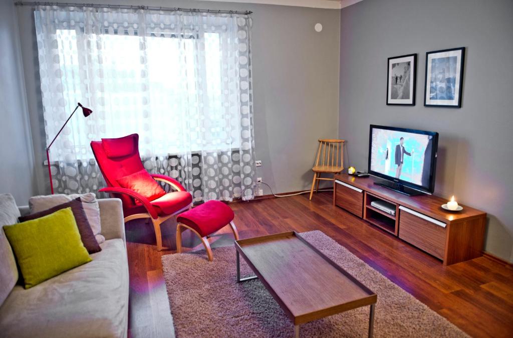 a living room with a couch and a tv at Helsinki Apartments in Helsinki