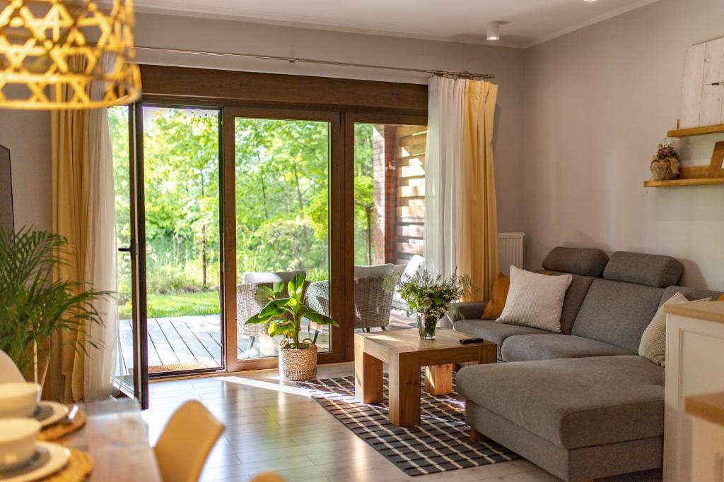ein Wohnzimmer mit einem Sofa und einem Tisch in der Unterkunft Apartament "Zacisze" z tarasem in Ostróda