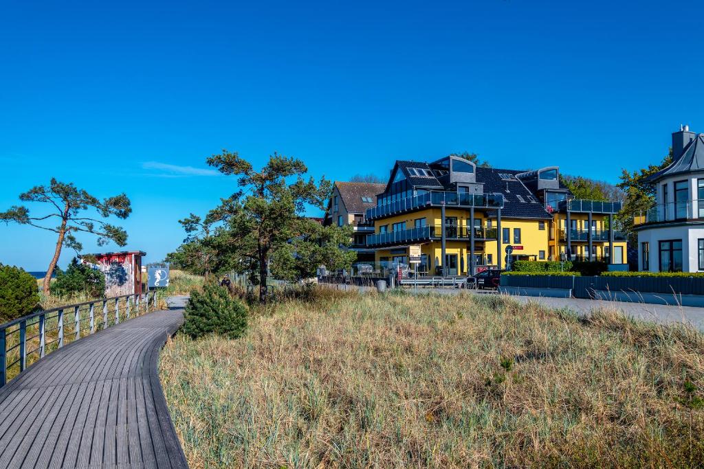 um calçadão que leva a casas na praia em Seaside-Strandhotel em Timmendorfer Strand