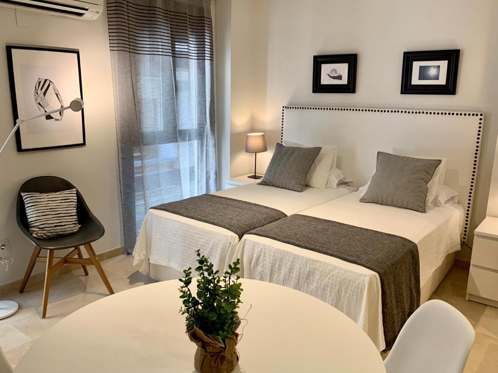1 dormitorio con 2 camas, mesa y silla en Apartamentos Rafael Loft, en Alicante