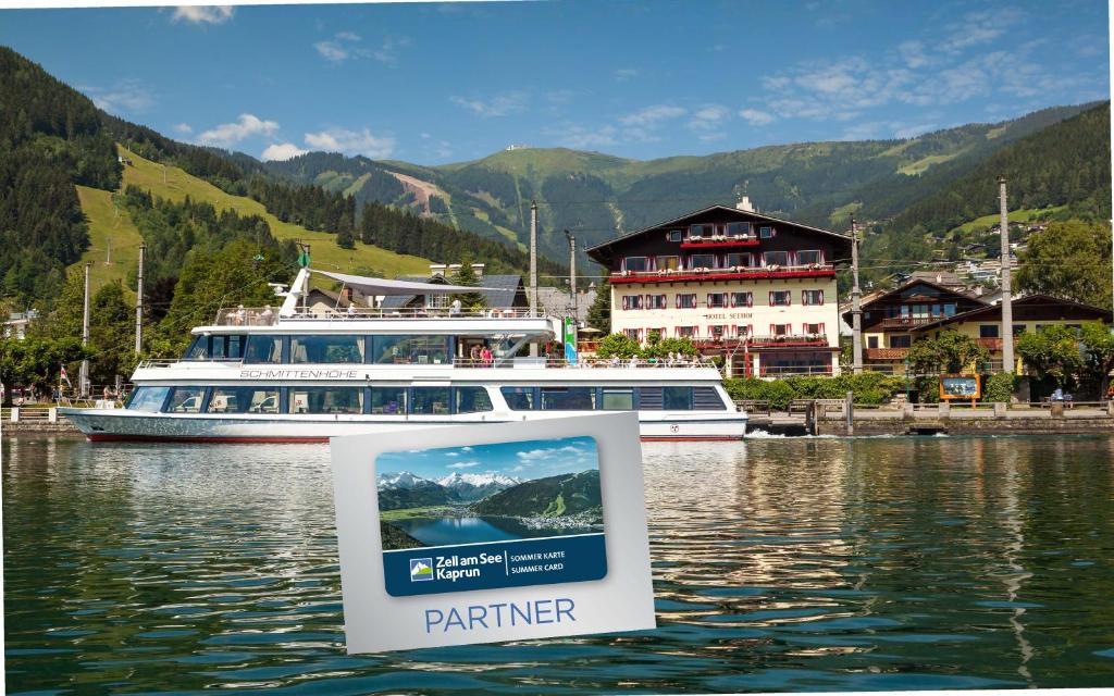 a boat on a lake with a sign in the water at Hotel Seehof in Zell am See