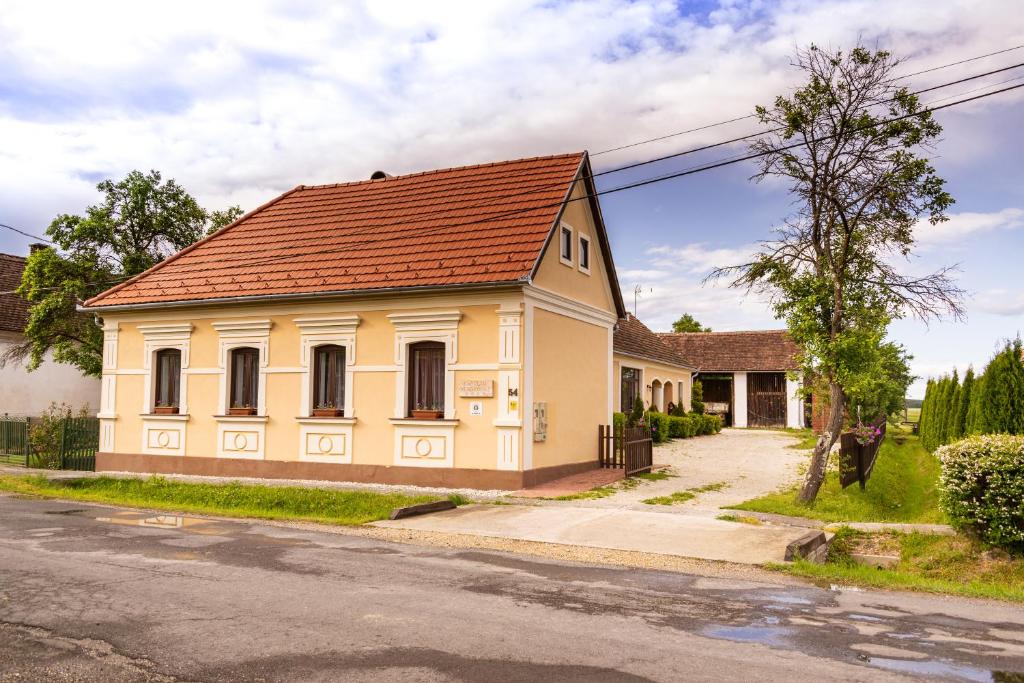 una pequeña casa amarilla con techo marrón en Kápolna Vendégház, en Kerkáskápolna