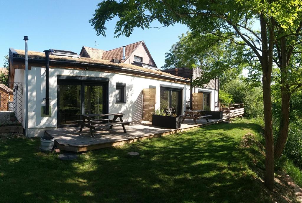 una casa con terraza de madera en el patio en Les Bords de L´Ill, en Illhaeusern