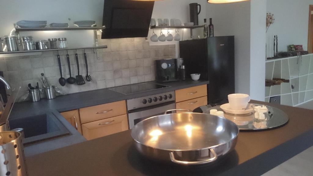 - une cuisine avec un grand bol en métal sur un comptoir dans l'établissement K82 apart HOTEL relax&work, à Kirchentellinsfurt