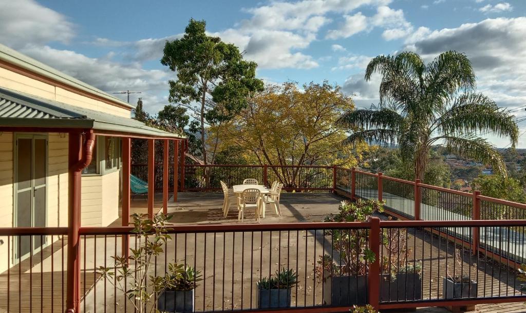 un balcón de una casa con mesa y sillas en Treetops Escape Albury en Albury