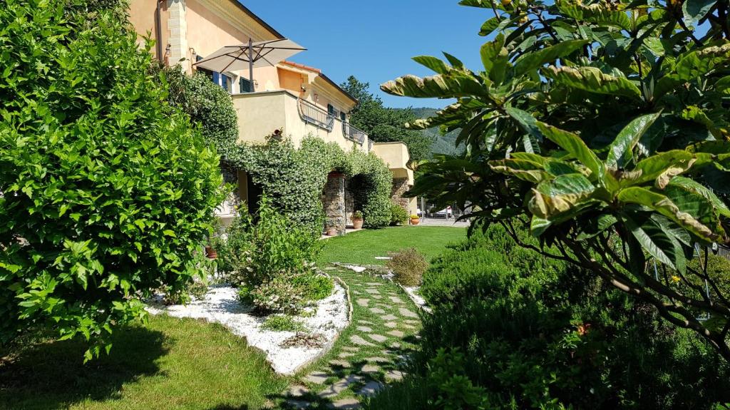 a garden with a house and a walkway at Villa Claudia in Quiliano