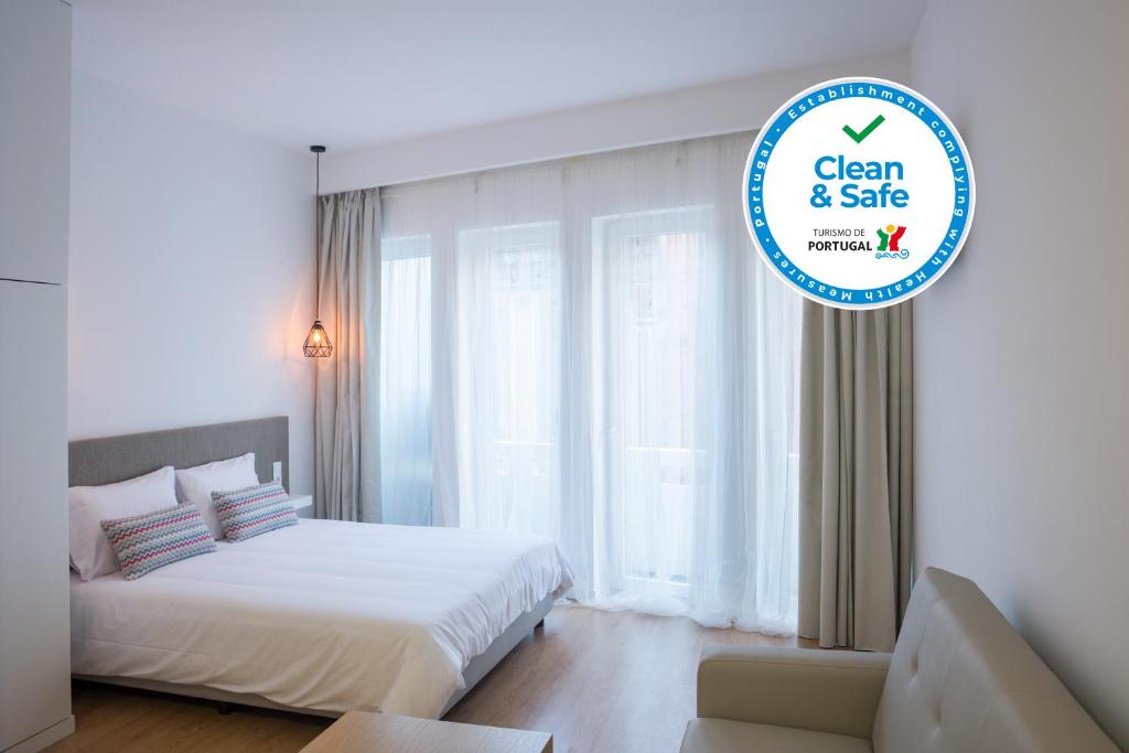 un dormitorio con una cama y un cartel que diga limpio y en venta en Porto Bonjardim Apartments, en Oporto