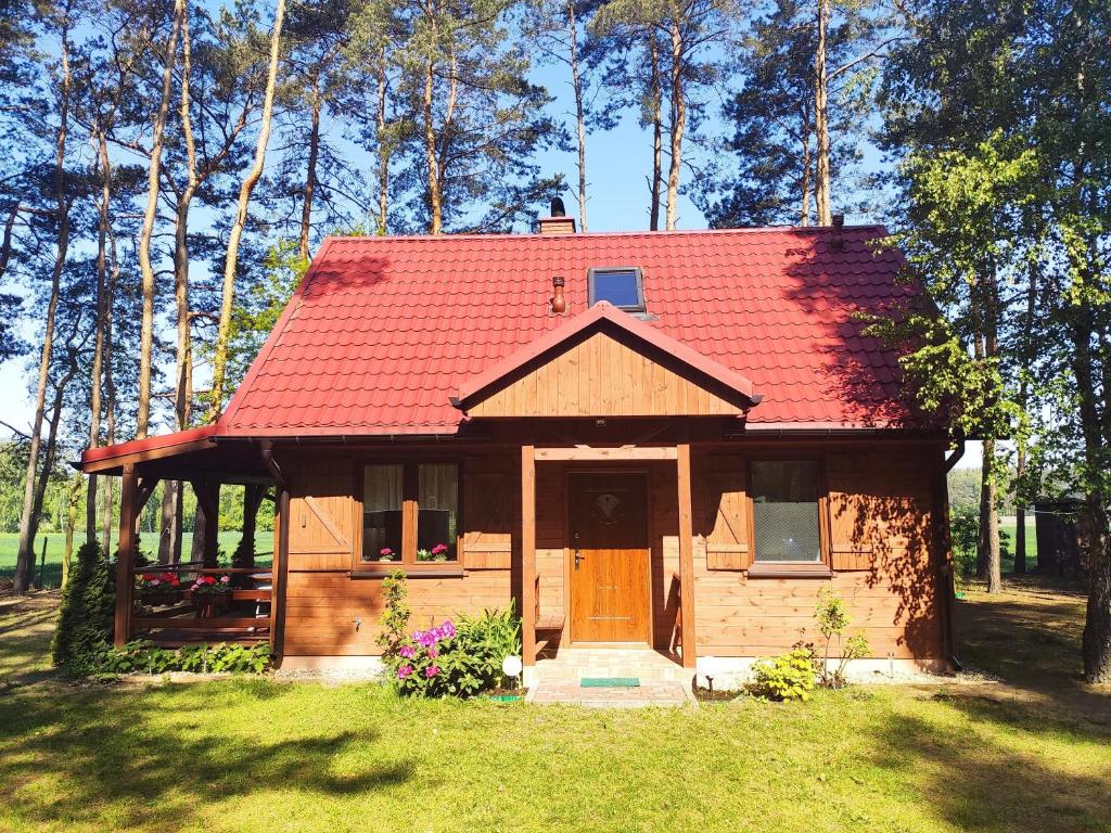 ein kleines Holzhaus mit rotem Dach in der Unterkunft Sunny House in Anielin in Anielin