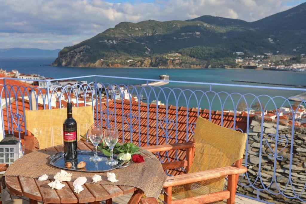 a table with a bottle of wine on a balcony at Alexandras traditional house in Skopelos centre in Karya