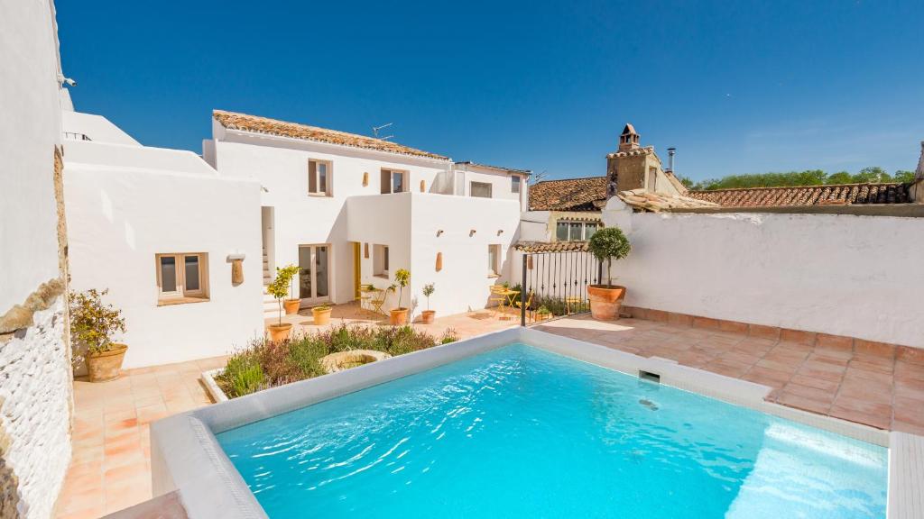 una piscina frente a una casa blanca en Romantic Ronda garden cottage, en Ronda