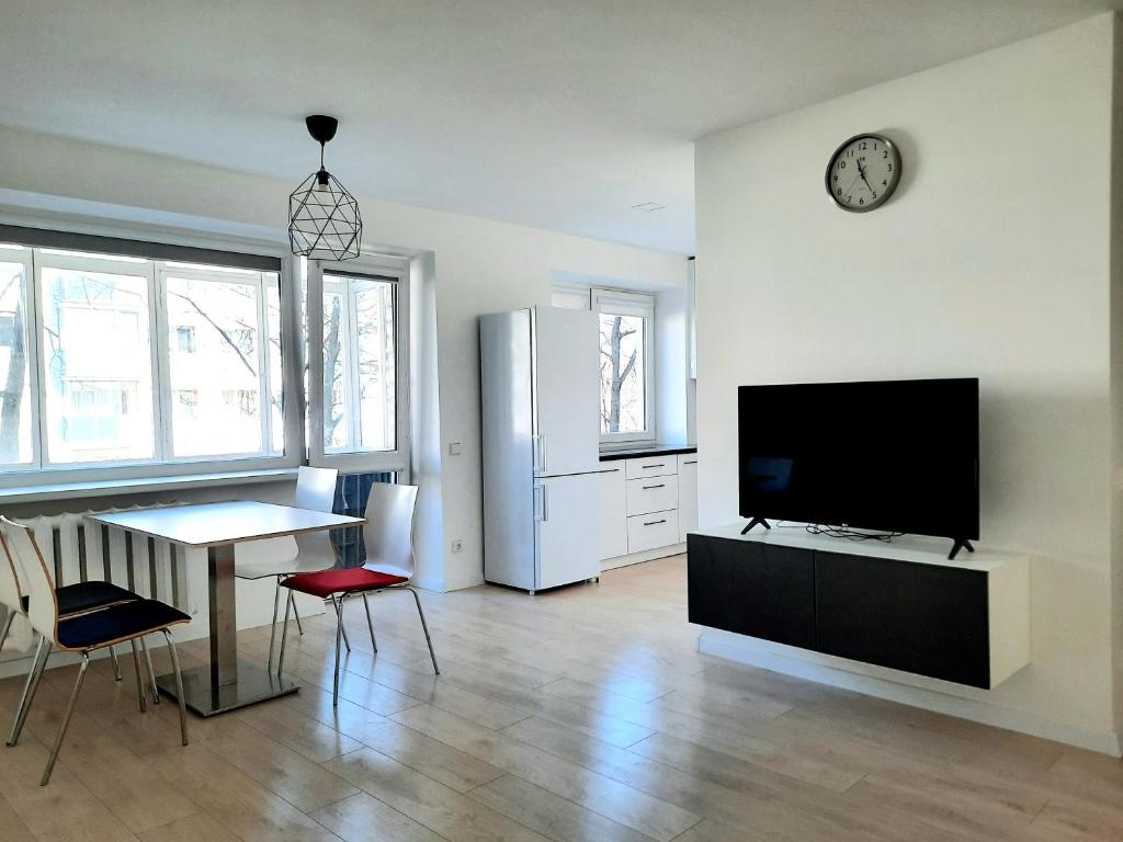 uma sala de estar com uma televisão, uma mesa e um frigorífico em Excellent Rest 2 rooms em Klaipėda