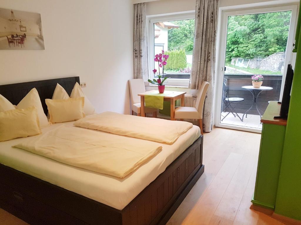 a bedroom with a bed and a balcony with a table at Apartment Gastein in Bad Gastein