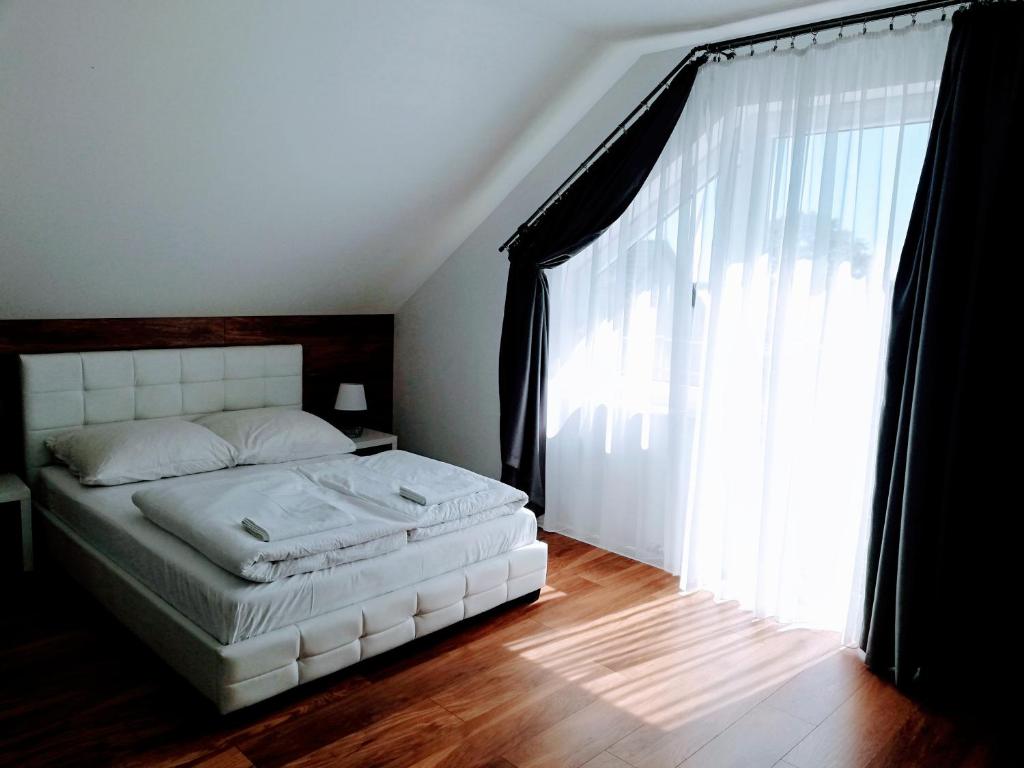 a bedroom with a bed and a large window at D.W. JULIA in Władysławowo