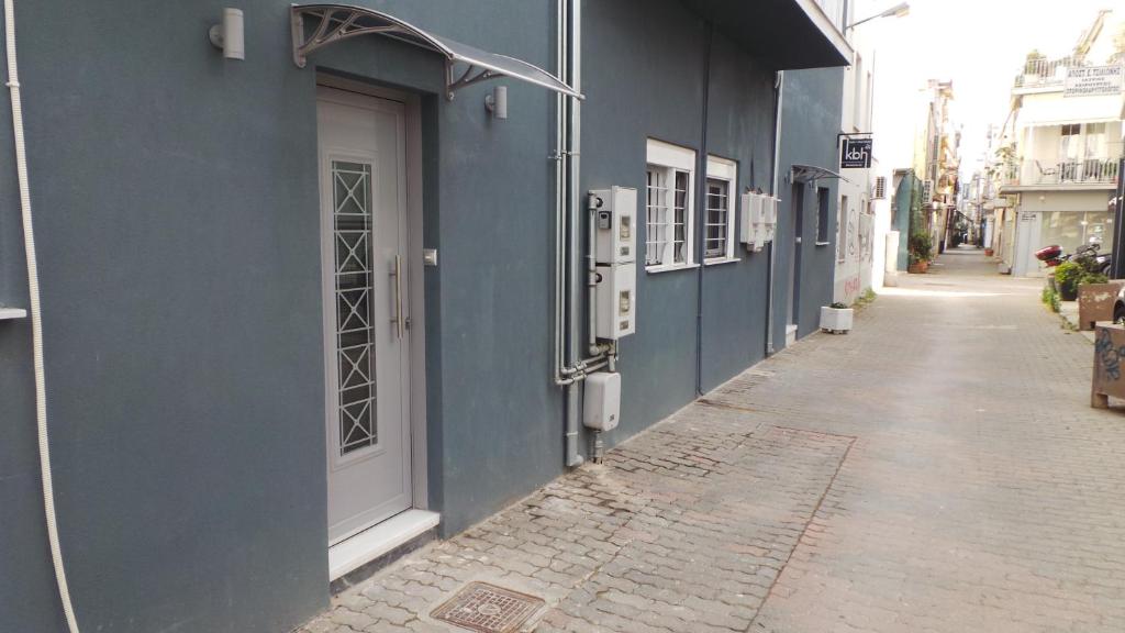 a blue building with a white door on a street at Katie's Blue House in Volos