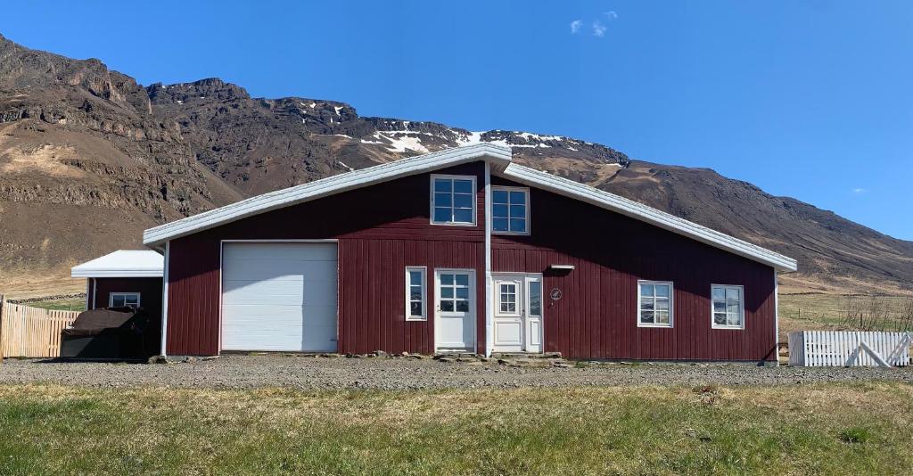 un fienile rosso con una montagna sullo sfondo di Hvammur 2 Guesthouse Red House a Blönduós