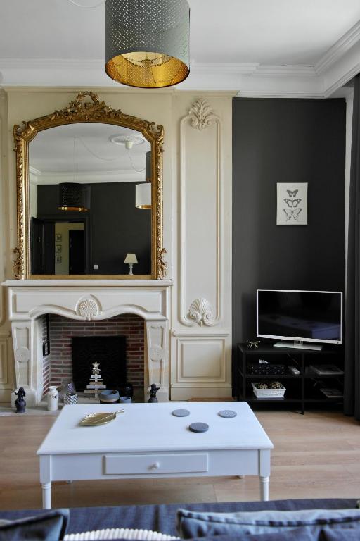 - un salon avec une table basse blanche et un miroir dans l'établissement Une Nuit au Soleil, à Bayeux