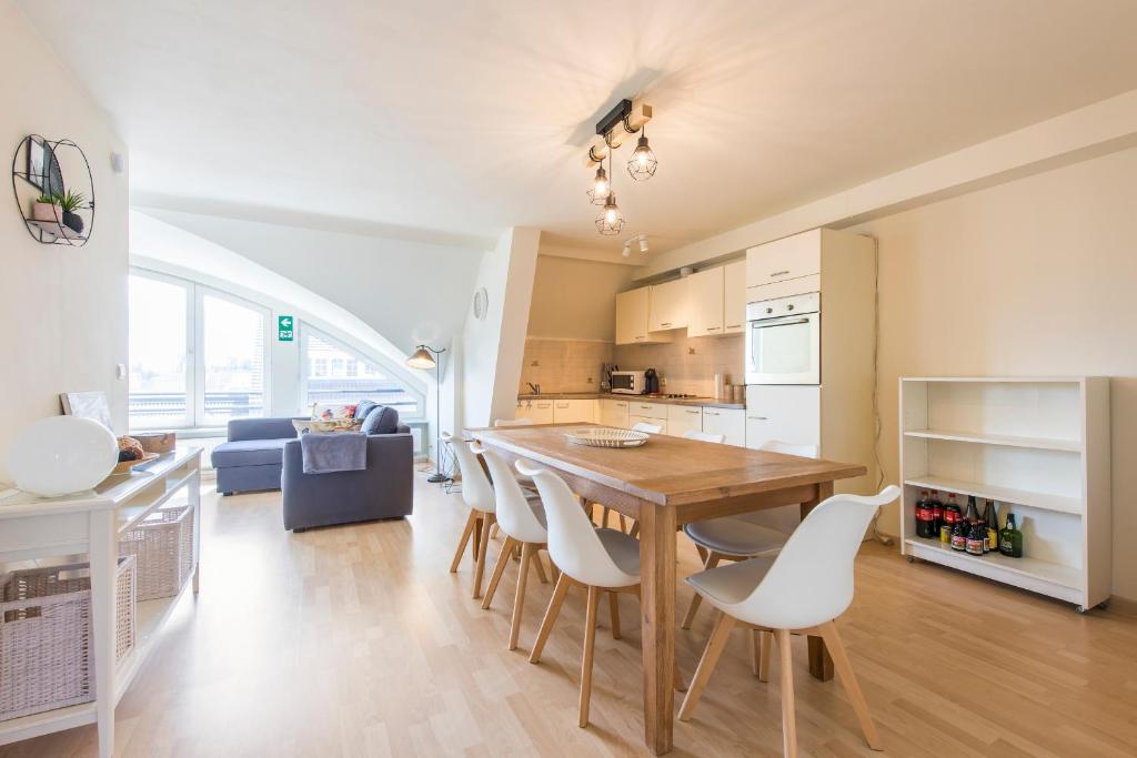 cocina y comedor con mesa de madera y sillas en Modern and Large 2 bedroom apartment in Middelkerke, en Middelkerke