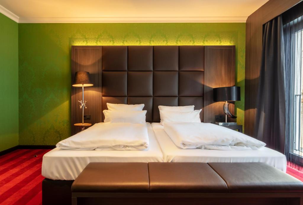 a bedroom with two beds and a large headboard at Haverkamp Suites in Bremerhaven