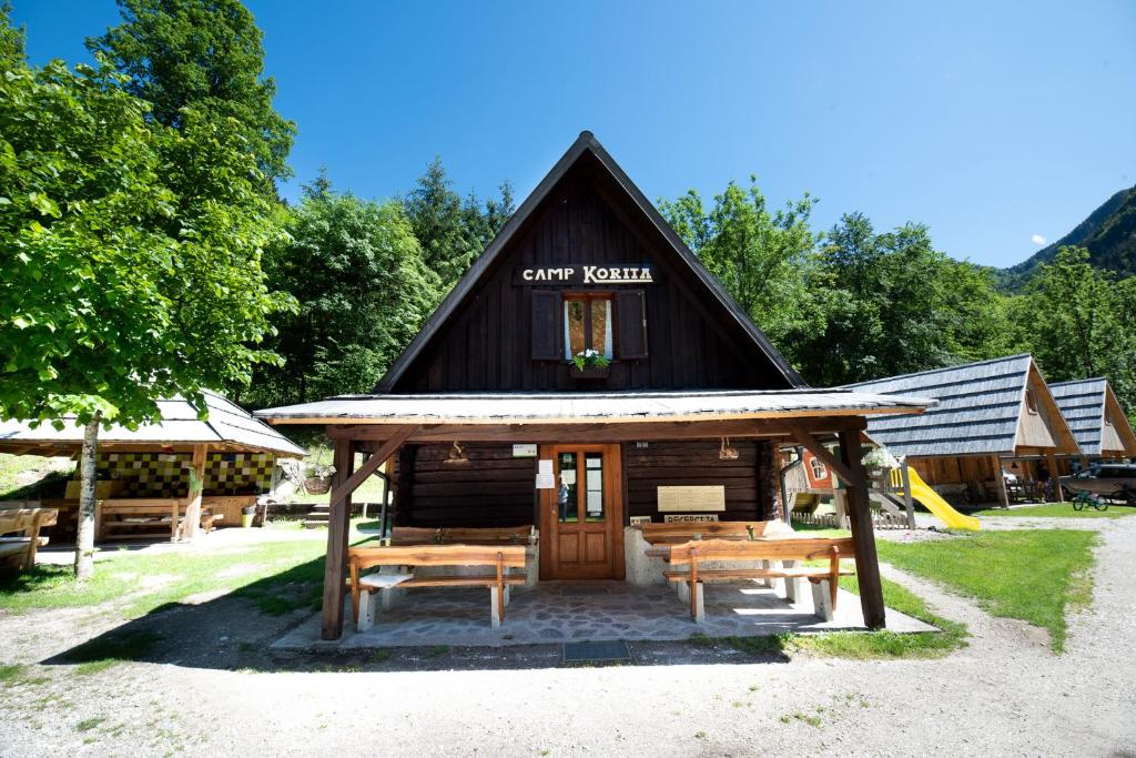 una pequeña cabaña con dos bancos delante en Camp Korita, en Soča