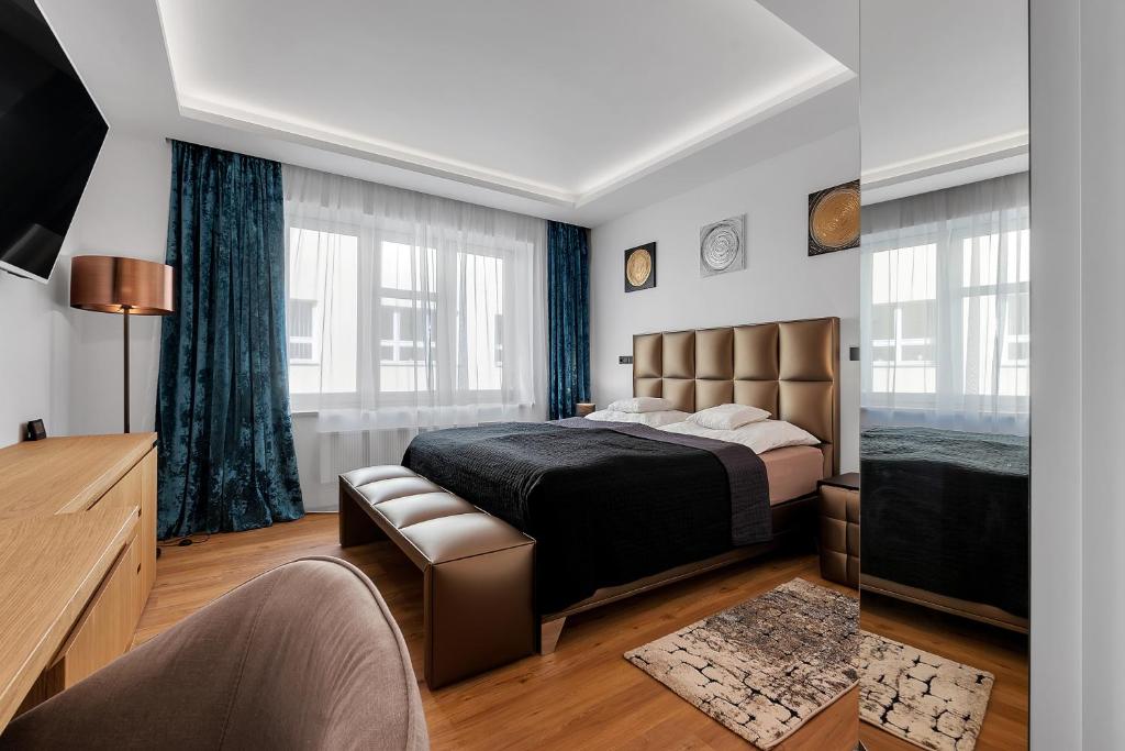 um quarto com uma cama, um sofá e uma televisão em Nový designový apartmán s klimatizací em Rychnov nad Kněžnou
