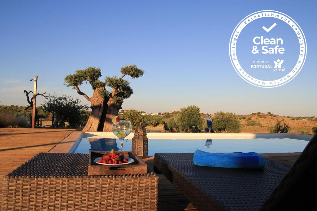 a table with a bowl of fruit and a wine glass at Espargosa Monte de Baixo & Art in Castro Marim