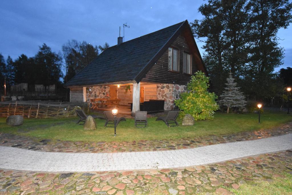 a log cabin with a table and chairs in front of it at Gintaro Vila in Kunigiškiai