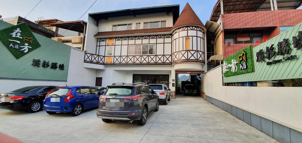 a car parked in a parking lot in front of a building at On One Side Homestay in Lugu Lake