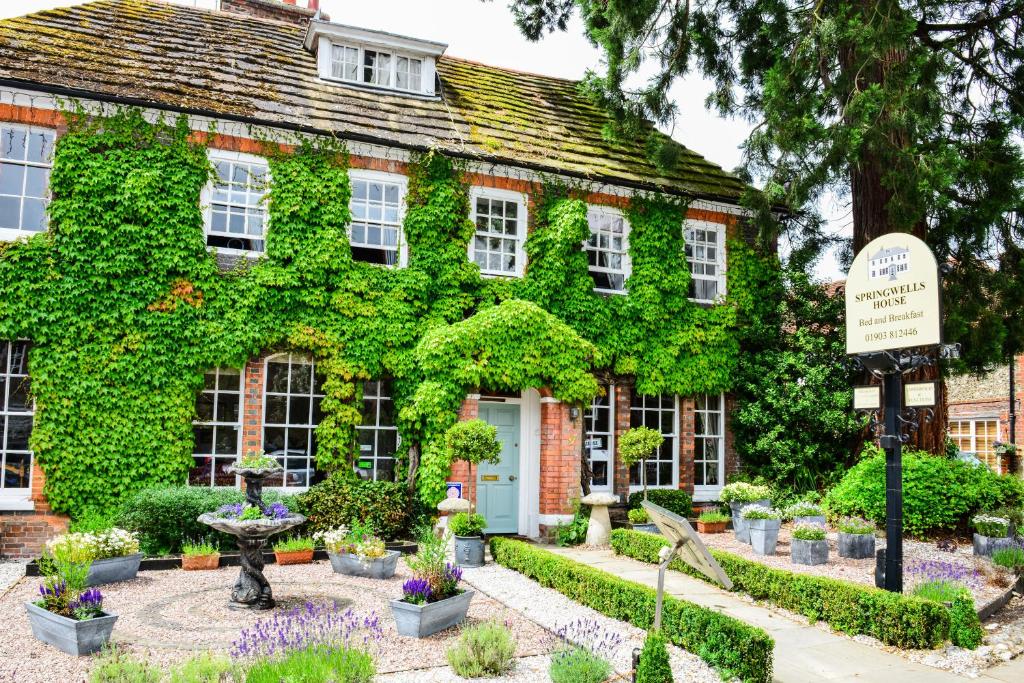 an ivy covered house with a garden in front of it at Springwells House in Steyning