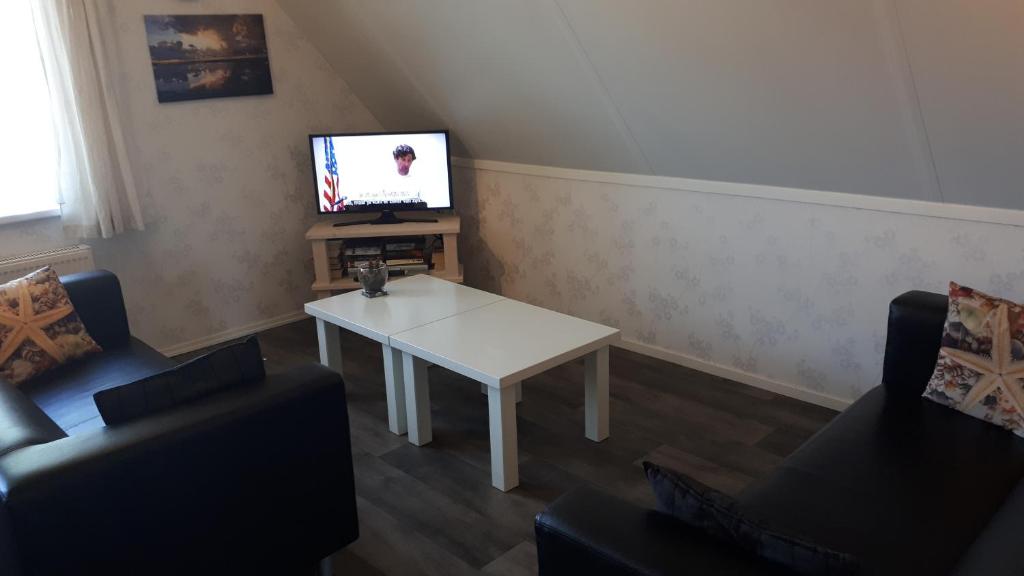 a living room with a white table and a tv at Appartement Esta in Buren