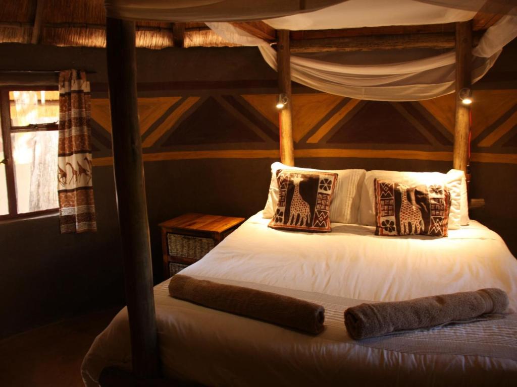 Bett in einem Zimmer mit Himmelbett in der Unterkunft Discovery Bed and Breakfast in Maun