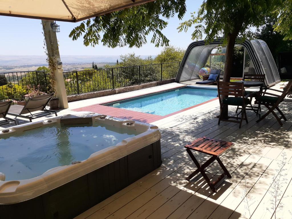 a hot tub on a deck with a table and chairs at Naomi's in Rosh Pinna