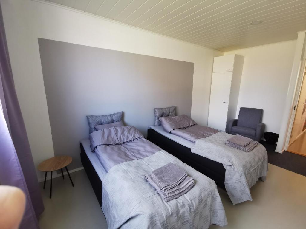 um quarto com duas camas e uma cadeira em Apartment Niittykatu em Raahe