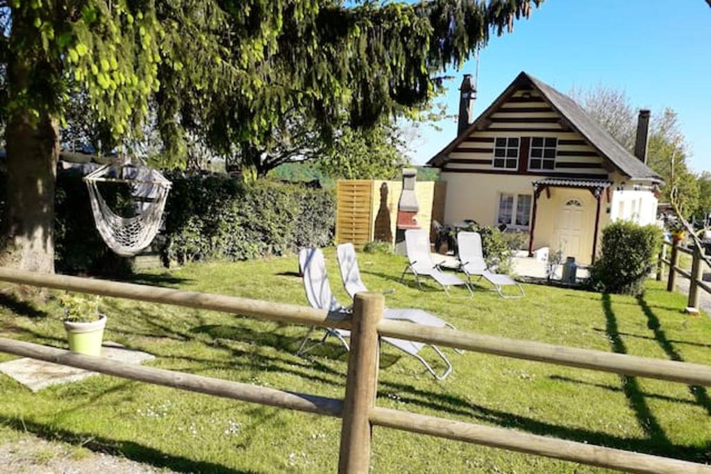 un grupo de sillas sentadas en el patio de una casa en Maison confortable avec jardin à Edruchon + Pour 6 personnes, en Saint-Martin-au-Bosc