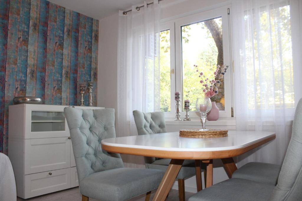 d'une salle à manger avec une table, des chaises et une fenêtre. dans l'établissement Holiday Apartment, à Mostar