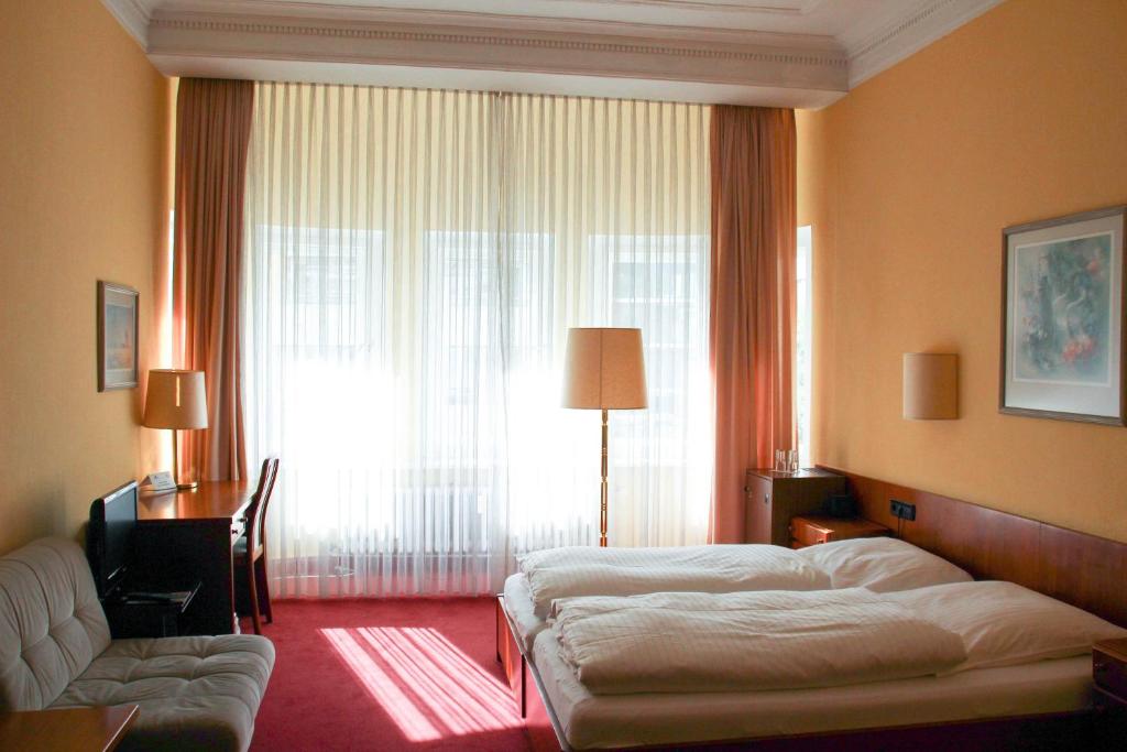 Postel nebo postele na pokoji v ubytování Kurfürst am Kurfürstendamm